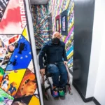 Man in wheelchair exiting colorful bathroom