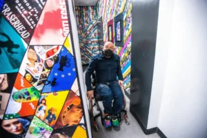 Man in wheelchair exiting colorful bathroom