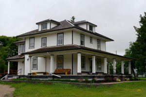Older white farmhouse with a porch
