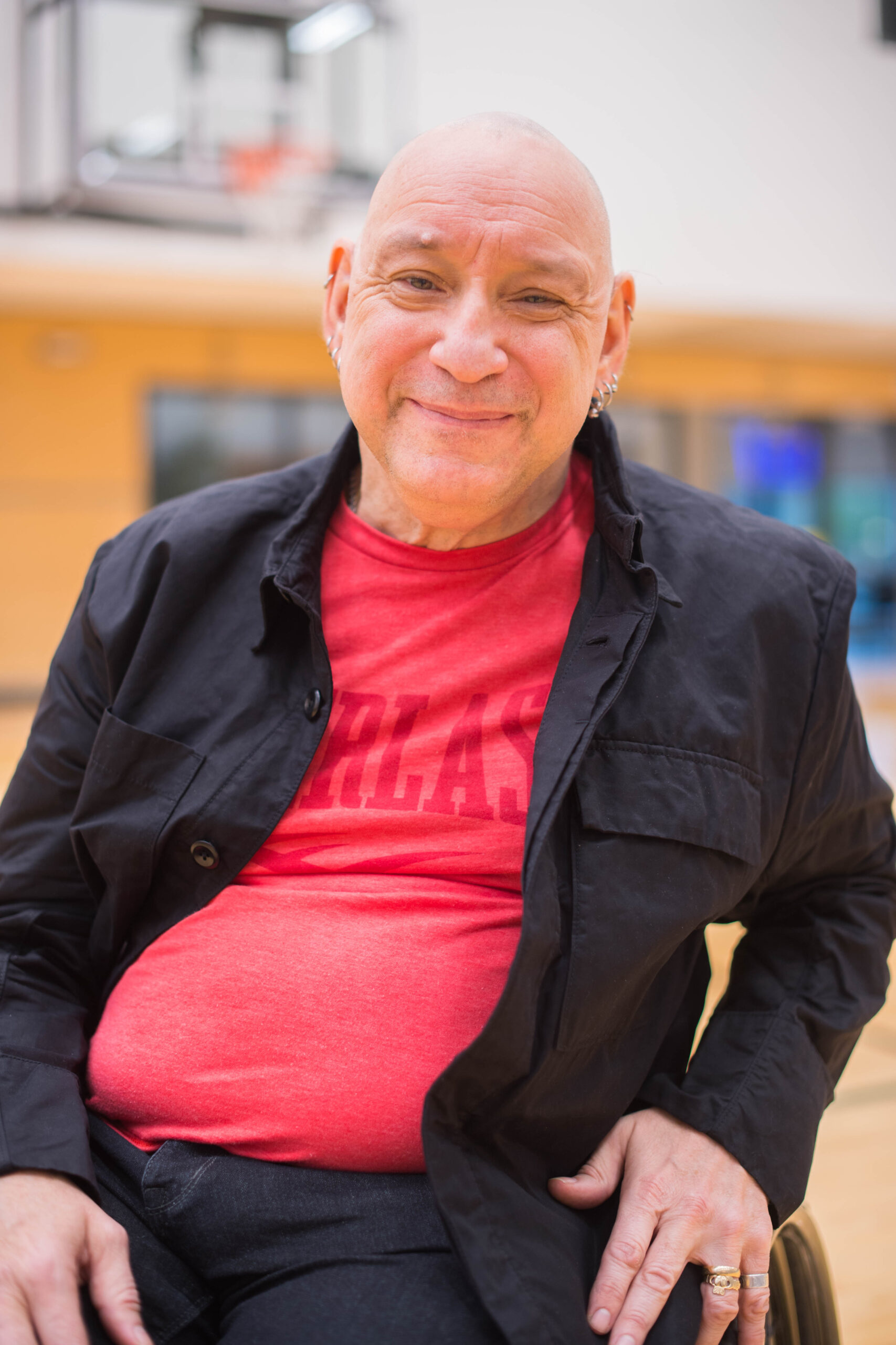 Picture of Peter Tonge in a red shirt with a dark overshirt. He is smiling.