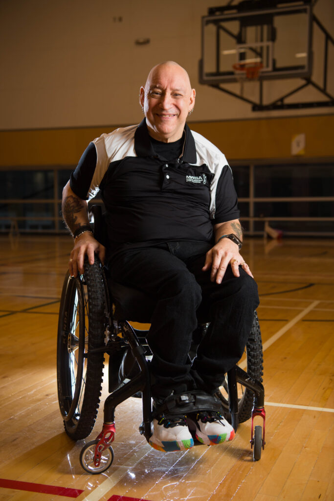 Picture of Peter Tonge, sitting in his wheelchair on a basketball court