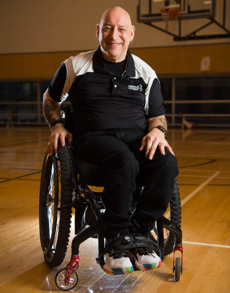 Picture of Peter Tonge, sitting in his wheelchair on a basketball court